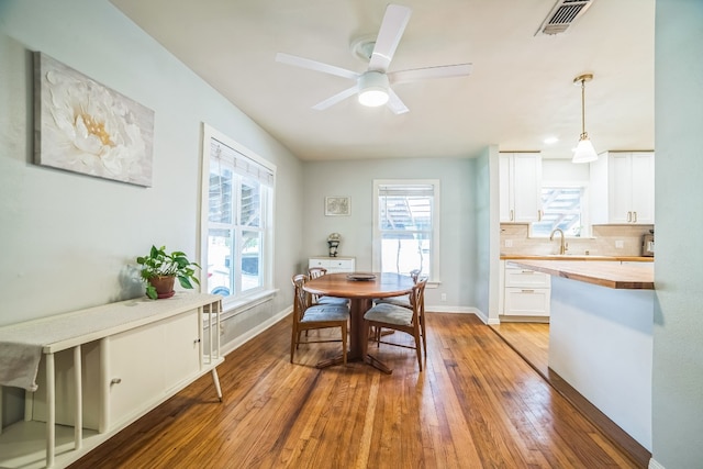 dining room featuring sink, a wealth of natural light, ceiling fan, and light hardwood / wood-style flooring