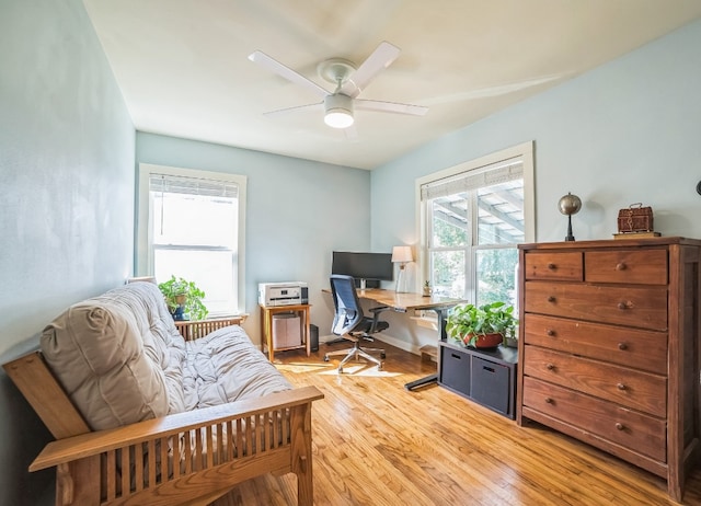 office with light hardwood / wood-style flooring and ceiling fan