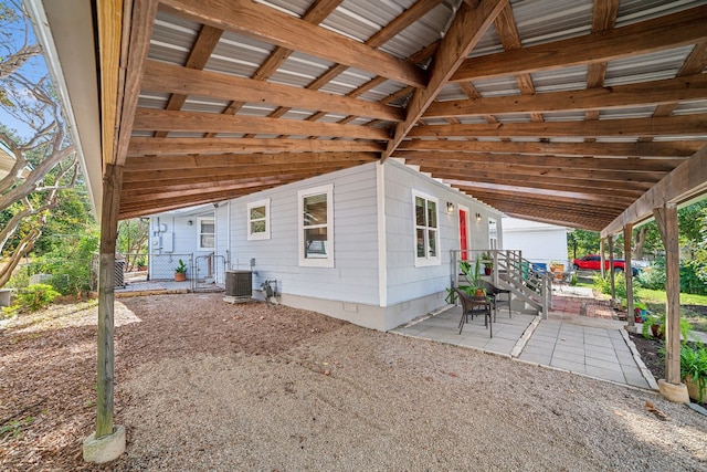 view of side of property with a patio area and central air condition unit