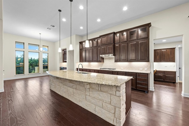 kitchen featuring a large island, decorative light fixtures, sink, and dark hardwood / wood-style flooring