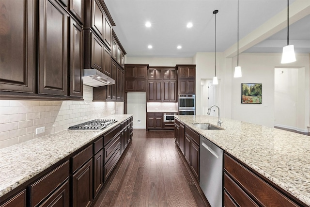 kitchen with appliances with stainless steel finishes, sink, dark brown cabinetry, decorative light fixtures, and dark hardwood / wood-style floors