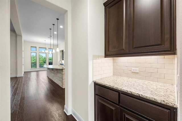 hallway with dark hardwood / wood-style flooring and an inviting chandelier