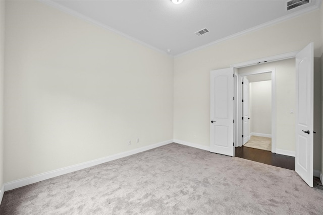 empty room featuring ornamental molding and carpet floors