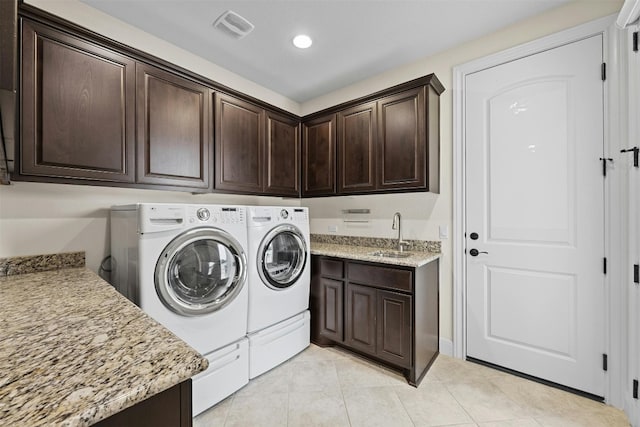 clothes washing area featuring cabinets, sink, separate washer and dryer, and light tile patterned floors