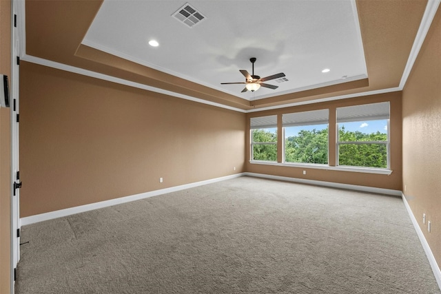 spare room with crown molding, a tray ceiling, and ceiling fan