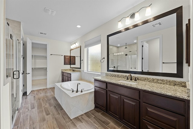 bathroom featuring vanity, hardwood / wood-style floors, and separate shower and tub