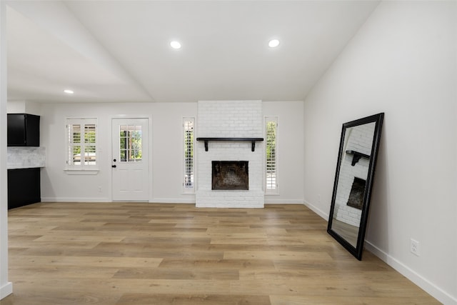 unfurnished living room featuring light hardwood / wood-style flooring and a fireplace