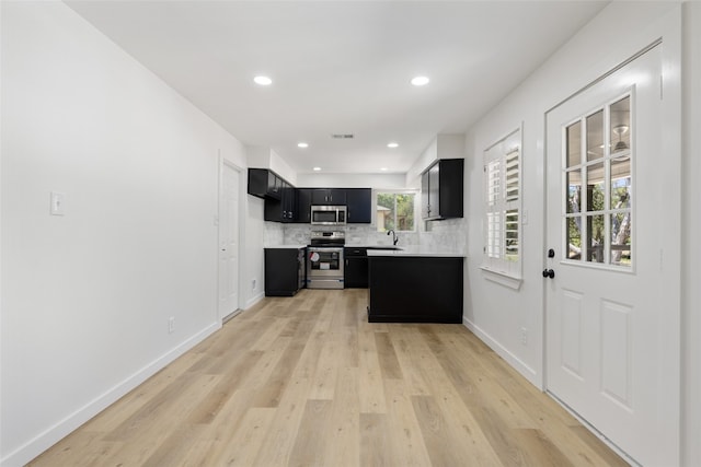 kitchen featuring light hardwood / wood-style floors, stainless steel appliances, sink, and backsplash