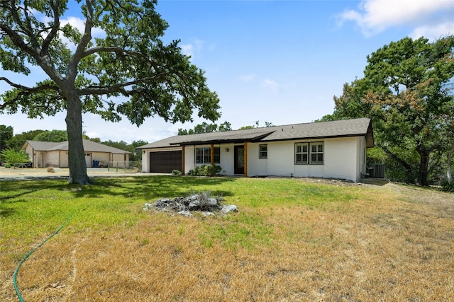 ranch-style home with a front lawn, central AC unit, and a garage