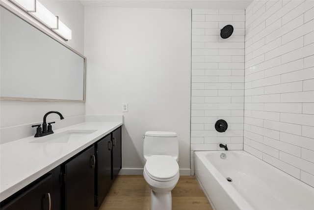 full bathroom featuring vanity, tiled shower / bath, toilet, and wood-type flooring