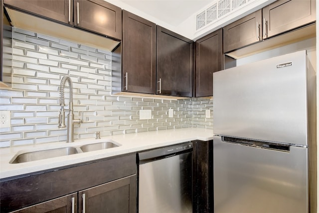 kitchen with dark brown cabinets, appliances with stainless steel finishes, sink, and decorative backsplash