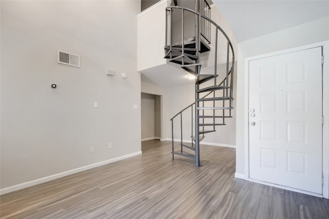 interior space featuring hardwood / wood-style floors and a towering ceiling