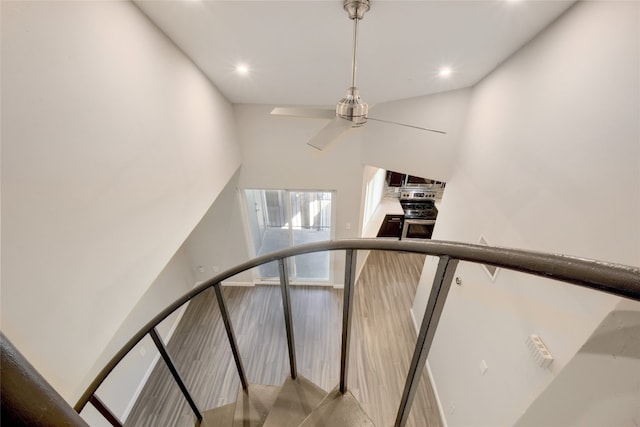 stairs with a towering ceiling and ceiling fan