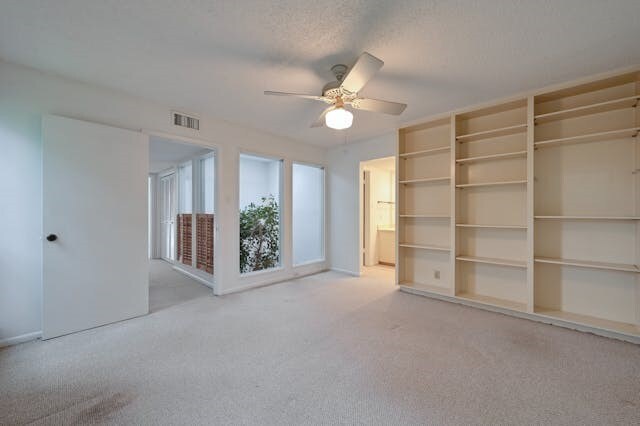 carpeted empty room featuring ceiling fan