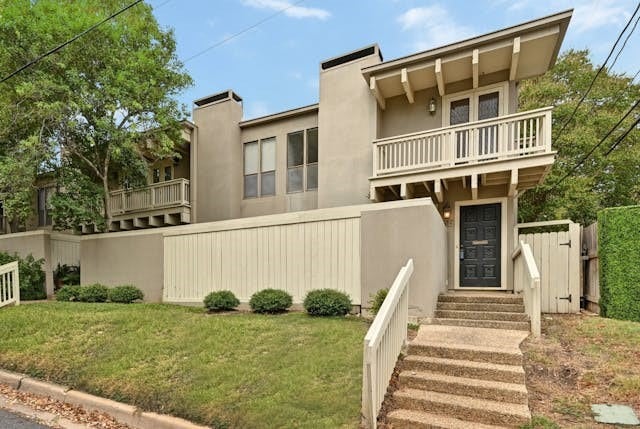 view of front of home featuring a front yard and a balcony