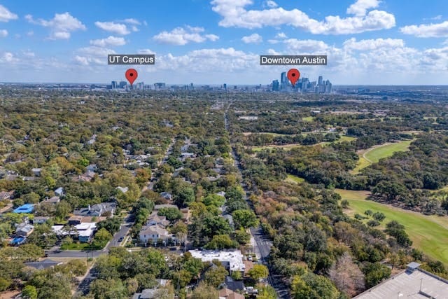 bird's eye view featuring a view of city and a wooded view