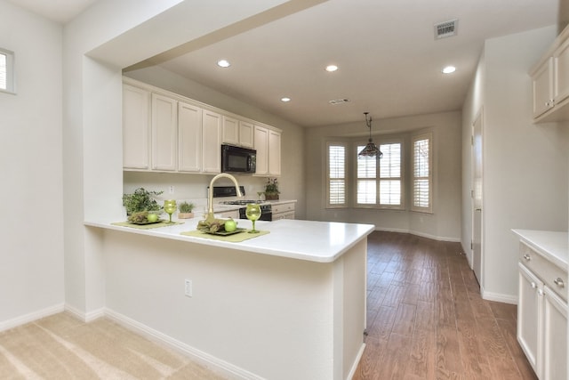 kitchen featuring light hardwood / wood-style floors, kitchen peninsula, and white cabinets