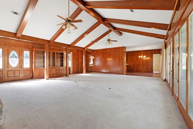 unfurnished living room with beam ceiling, light colored carpet, and wooden walls