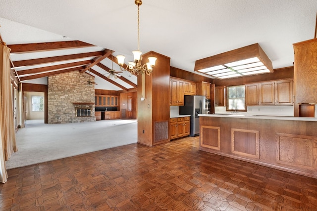 kitchen featuring lofted ceiling with beams, decorative light fixtures, ceiling fan with notable chandelier, and plenty of natural light