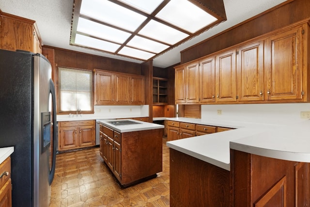 kitchen featuring a center island, sink, electric stovetop, and stainless steel fridge with ice dispenser