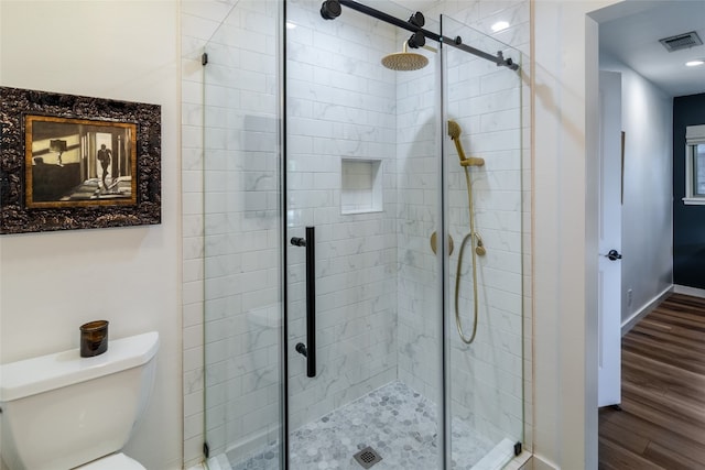 bathroom with toilet, hardwood / wood-style flooring, and a shower with shower door