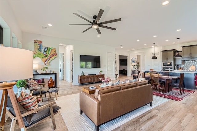 living room with light wood-type flooring and ceiling fan