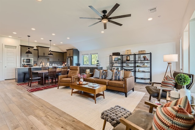 living room with light hardwood / wood-style floors, sink, and ceiling fan