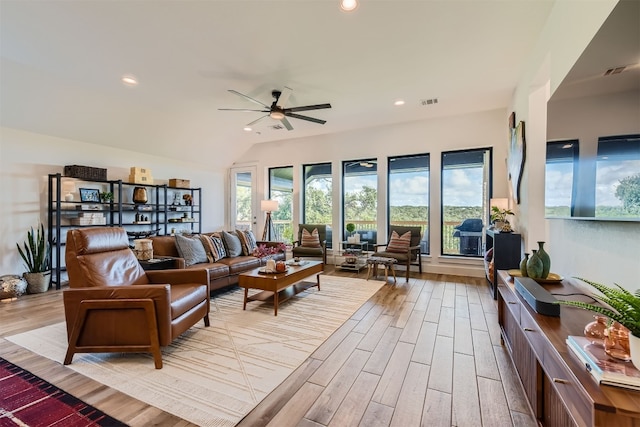 living room with vaulted ceiling, light wood-type flooring, and ceiling fan