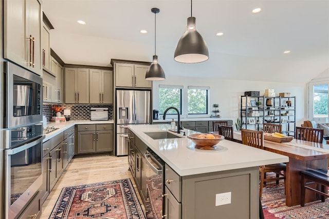 kitchen featuring appliances with stainless steel finishes, sink, a center island with sink, and plenty of natural light