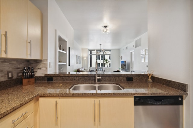 kitchen featuring tasteful backsplash, light brown cabinetry, sink, dark stone counters, and stainless steel dishwasher