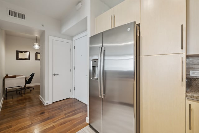 kitchen featuring stone counters, stainless steel fridge, decorative backsplash, and dark wood-type flooring