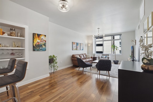 interior space with an inviting chandelier, hardwood / wood-style floors, and built in features