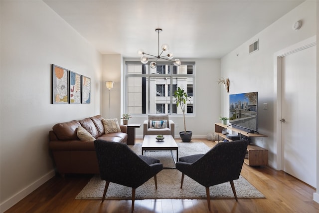 living room featuring an inviting chandelier and hardwood / wood-style flooring