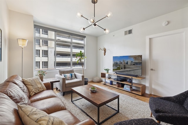 living room featuring hardwood / wood-style flooring and an inviting chandelier