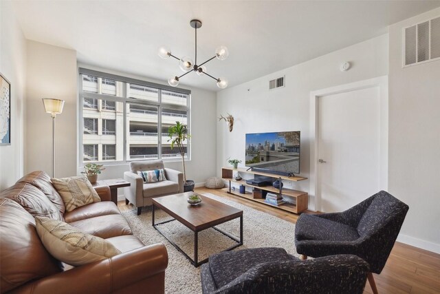 54 Rainey St Unit 503, Austin, TX 78701 - living area featuring baseboards, a notable chandelier, wood finished floors, and visible vents
