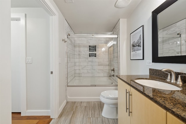 full bathroom with vanity, toilet, and bath / shower combo with glass door