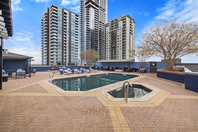 view of swimming pool with a patio and a hot tub