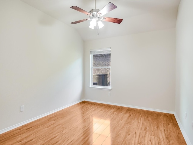 empty room with vaulted ceiling, light hardwood / wood-style flooring, a brick fireplace, and ceiling fan