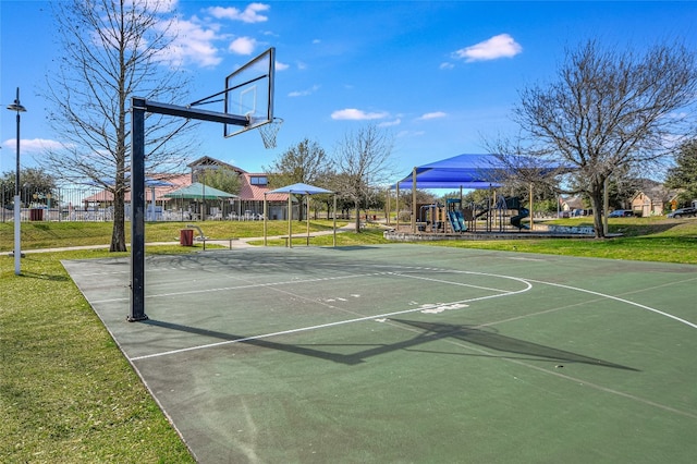 view of basketball court featuring a playground and a yard