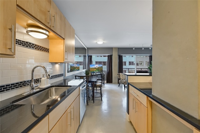 kitchen with tasteful backsplash, sink, light brown cabinets, and dishwasher