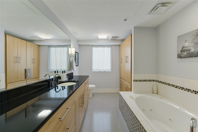 bathroom with vanity, toilet, a relaxing tiled tub, and concrete flooring