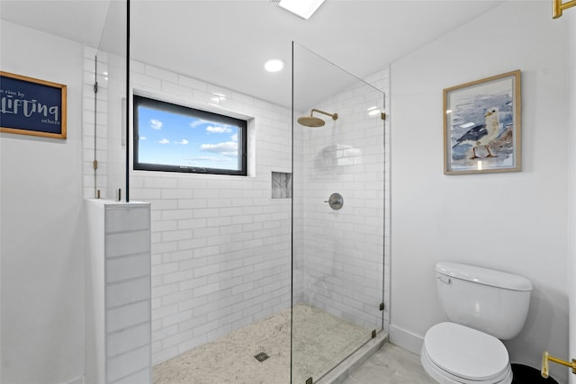 bathroom with toilet and a tile shower