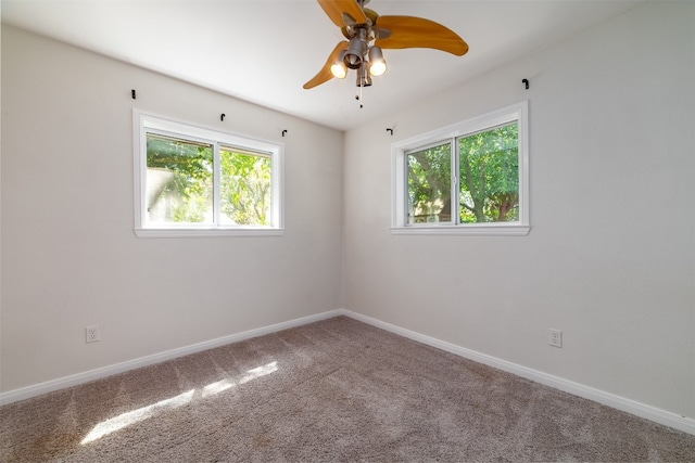 spare room featuring a wealth of natural light, carpet flooring, and ceiling fan