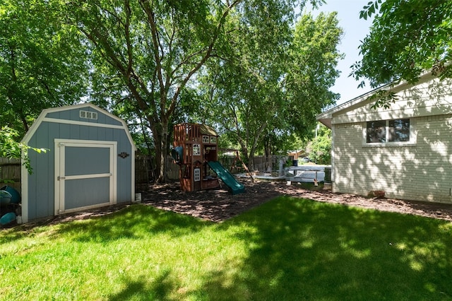 view of yard featuring a storage unit and a playground