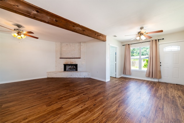 unfurnished living room featuring dark hardwood / wood-style flooring, beamed ceiling, a fireplace, and ceiling fan