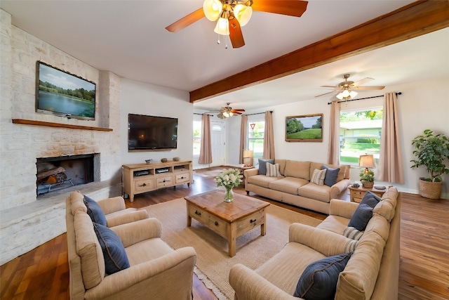 living room featuring ceiling fan, a stone fireplace, and hardwood / wood-style floors