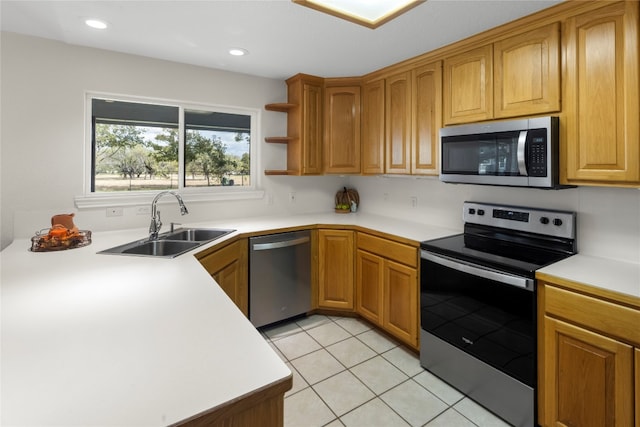 kitchen with appliances with stainless steel finishes, light tile patterned floors, and sink