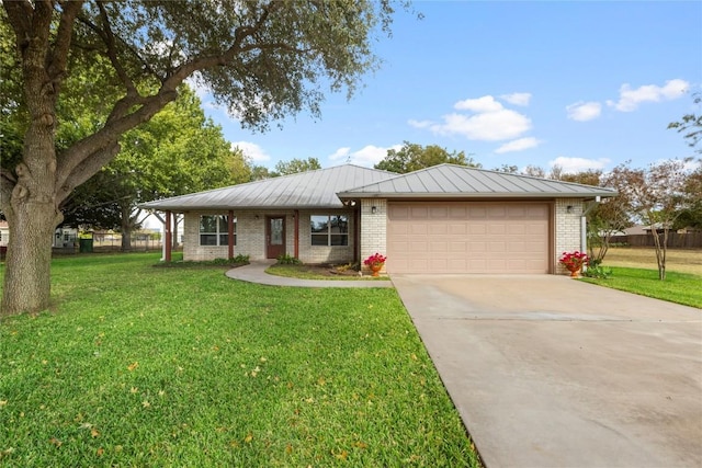 116 Wren St, Highland Haven, TX 78654 - ranch-style house with brick siding, concrete driveway, a garage, a front yard, and a standing seam roof