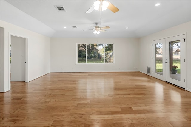 empty room featuring a wealth of natural light, french doors, ceiling fan, and light hardwood / wood-style floors