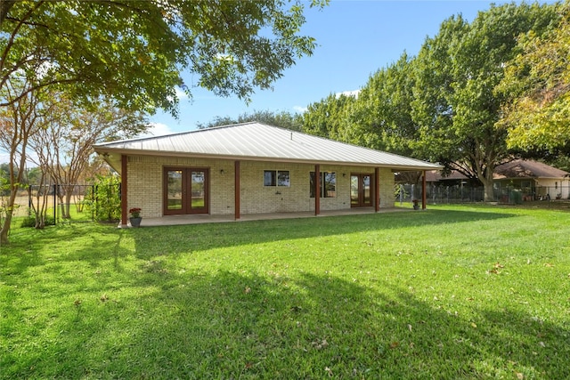 back of house featuring a lawn, a patio area, and french doors